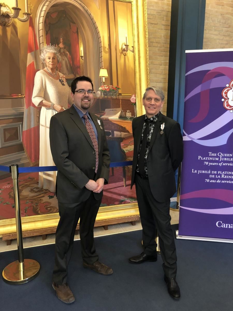Jeremy Mohr and Donald Johnson in front of portrait of Queen Elizabeth II